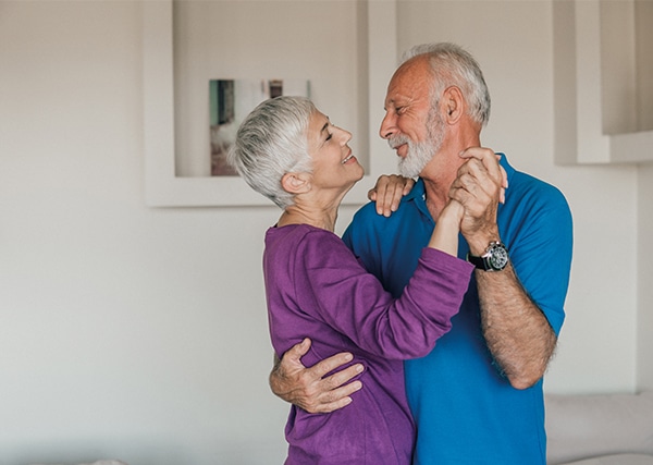 Older couple dancing and smiling at each other